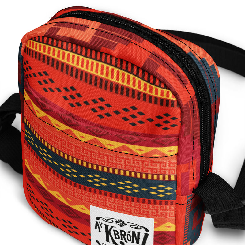 Bolso bandolera utilitario en tonos rojos con grecas zapotecas